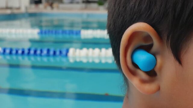 Child with earplugs in a swimming pool.