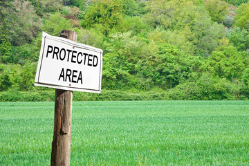 Obraz premium Protected area written on a field sign - Sign indicating in the countryside - image with copy space