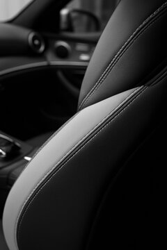 Modern black and grey leather car seat interior with detailed white stitching