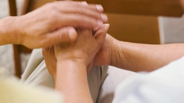 View of senior man's hands caressing and holding senior woman's hands. Affectionate elderly couple holding hands. Senior husband hold his wife's hands.