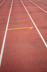 Fototapeta premium Empty running track with directional arrow and white lane lines