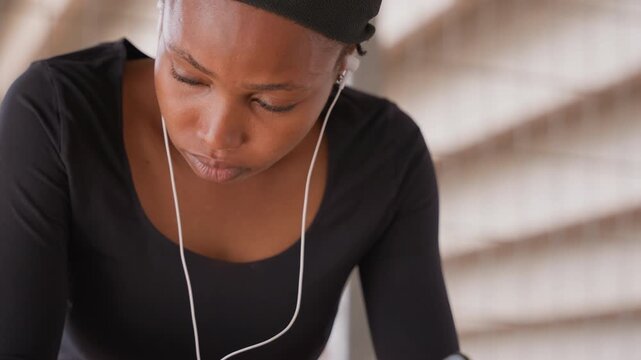Creative woman deeply immersed in drawing with braided hair and background ambiance. Artist diligently working on her masterpiece while wearing earbuds and concentrating on her art in peaceful setting