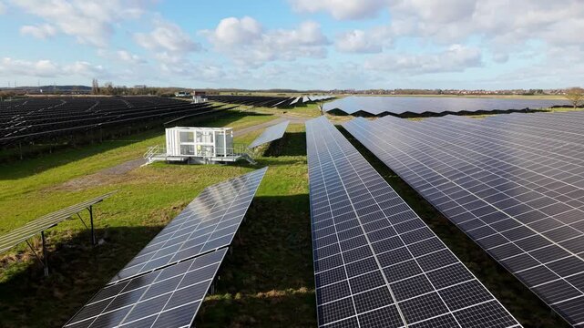 Close up aerial view over a modern solar panel array and battery transformer units on a sunny day near Immingham UK for renewable energy.