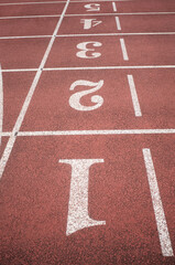 Empty running track with lane numbers and white lines