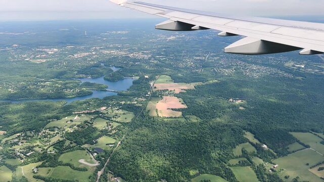 Airplane wing above patchwork countryside. High quality 4k footage