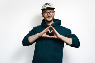 Obraz premium Young smiling guy showing heart with hands isolated on white background.