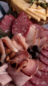 Cinematic close up of gourmet catering boards featuring fontina, gouda, tybo, gruyere and blue cheese with prosciutto, ham, pancetta, bondiola, salami, longaniza, olives and almonds for elegant events