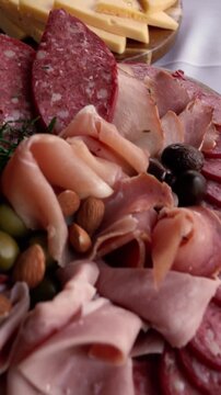 Cinematic close up of gourmet catering boards featuring fontina, gouda, tybo, gruyere and blue cheese with prosciutto, ham, pancetta, bondiola, salami, longaniza, olives and almonds for elegant events