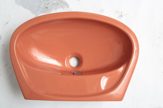 Retro coral pink bathroom sink basin with a smooth glossy finish and clean lines
