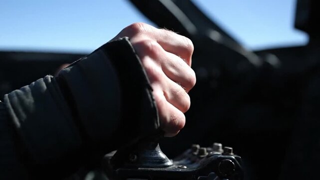 Gripping hand operating manual controls inside cockpit