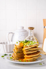 Tasty savory breakfast pancakes with spring green onion and fried eggs