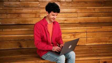 Happy, smiling, successful man freelancer using laptop copywriter typing on keyboard