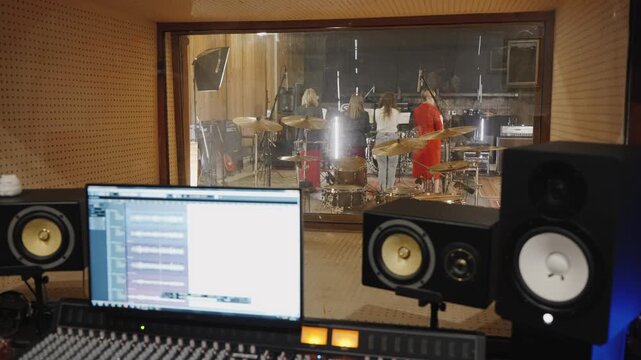 Musicians perform while engineer manages sound with visual equipment