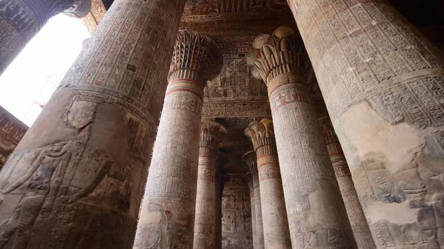 Egypt. Esna temple hypostyle hall with massive painted columns and colorful hieroglyphic reliefs on ceiling in Egypt, ancient Roman-era architecture with preserved pigments and carvings.