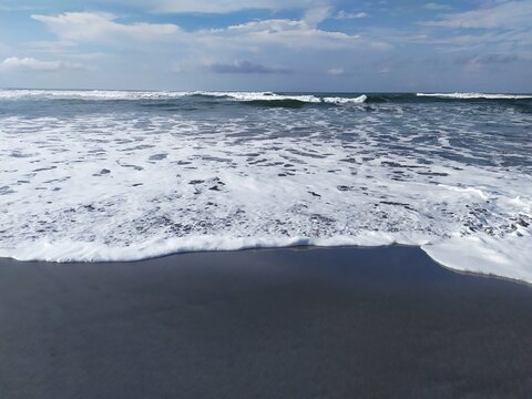Ombak yang berbuih di tepi pantai