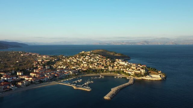 Scenic aerial view of Paralio Astros coastal town and marina on a sunny day, surrounded by the blue waters of the Argolic Gulf in Greece.