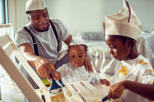 Father and children painting furniture at home