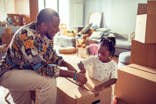 Father and daughter packing moving boxes at home