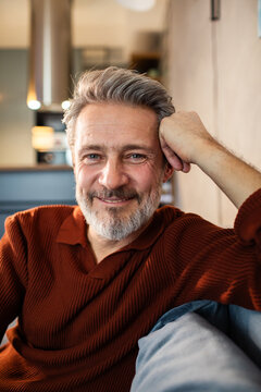 Smiling middle-aged man relaxing at home