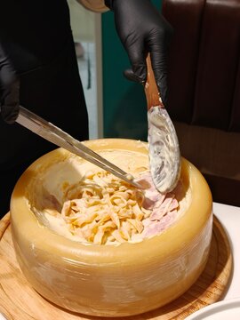 Chef Serving Fettuccine Pasta in Parmesan Cheese Wheel