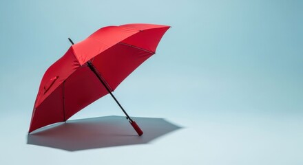 Red umbrella open, laying down. Cast shadow. Simple scene