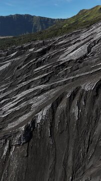 Aerial drone shot over dramatic volcanic textures of Mount Bromo landscape