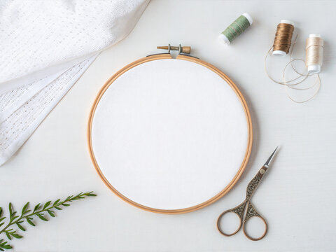Embroidery hoop with scissors and thread on white workspace