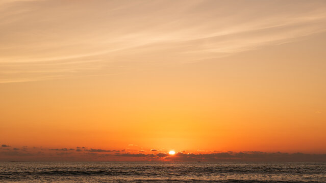 Sunset sky Clouds over sea in the Evening with Orange, Yellow sunlight on golden hour, Horizon sea sky landscape nature background, Summer sea Sky