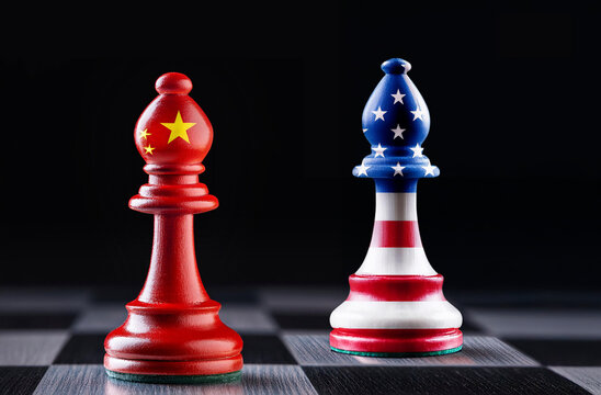 Dwa pionki w narodowych barwach USA i Chin na szachownicy jako ilustracja gospodarczej i politycznej rywalizacji amerykańsko chińskiej o przyw&oacute;dztwo nad światem