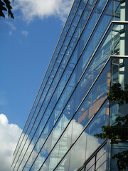 Architectural Detail Of Contemporary Office Building Window, Modern Glass Facade Reflecting Blue Sky And White Cloud