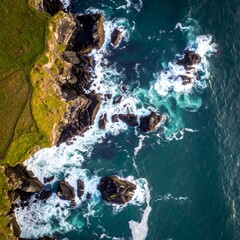 Aerial view of coastal rocks, waves crashing against the shore