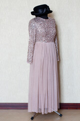 A beautiful women's dress on a mannequin with a hat