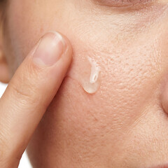 Fototapeta premium Close-up of woman applying skincare cream on her face