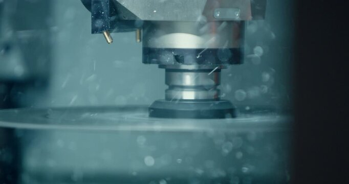 Industrial milling machine spindle processing metal workpiece with particles