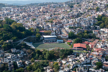 A panoramic view of Taxco, Guerrero, Mexico, highlighting a soccer field surrounded by hillside homes and nature © Enrique