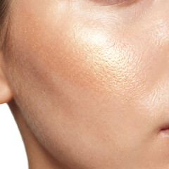 Close-up of glowing cosmetic highlighter applied on cheekbone  