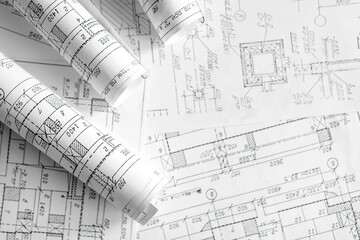 Architecture blueprints with rolled plans, compass and clipboard on desk, construction documentation and engineering design workflow,planning and project management concept, copy space.