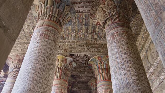 Egypt. Esna temple hypostyle hall with massive painted columns and colorful hieroglyphic reliefs on ceiling in Egypt, ancient Roman-era architecture with preserved pigments and carvings.