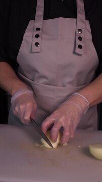 The cook's hands are cutting white onions in close-up. Cooking healthy food and homemade dishes