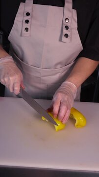 The cook is slicing bell peppers for the salad. We prepare healthy meals and homemade dishes