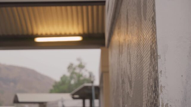 Tranquil setting with distant views. Serene cinematic lighting reveals weathered walls and faraway hills. Gentle lighting enhances textured exterior and peaceful landscape in quiet suburban area