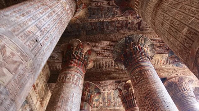 Egypt. Esna temple hypostyle hall with massive painted columns and colorful hieroglyphic reliefs on ceiling in Egypt, ancient Roman-era architecture with preserved pigments and carvings.