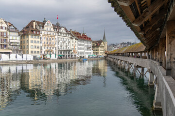 Obraz premium medieval wooden bridge with tower, mirroring in the water, center of Lucerne, a landmark of the city, old town of Lucerne, Switzerland, surrounded by beautiful old houses with shutters and paintings.