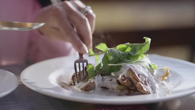 Business woman eat grilled beef steak with cream sauce and vegetables served on plate with hot steam, cinematic isolated slow motion shot