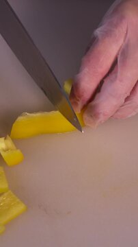 The cook is slicing bell peppers for the salad. We prepare healthy meals and homemade dishes