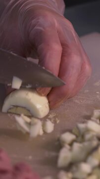 The cook cuts boiled eggs for salad. We prepare healthy meals