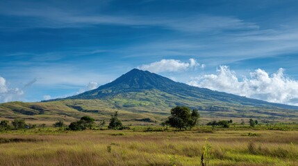 Obraz premium Majestic Mountain Landscape Under Bright Blue Sky with Fluffy Clouds and Green Hills in the Foreground Showcasing the Beauty of Nature in Daylight