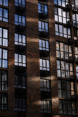 Obraz premium Modern brick apartment building with large windows and balconies