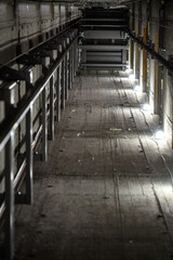 Fototapeta premium Industrial elevator shaft with illuminated pathway and metal framework