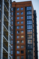 Fototapeta premium Modern residential apartment building with brick and glass facade